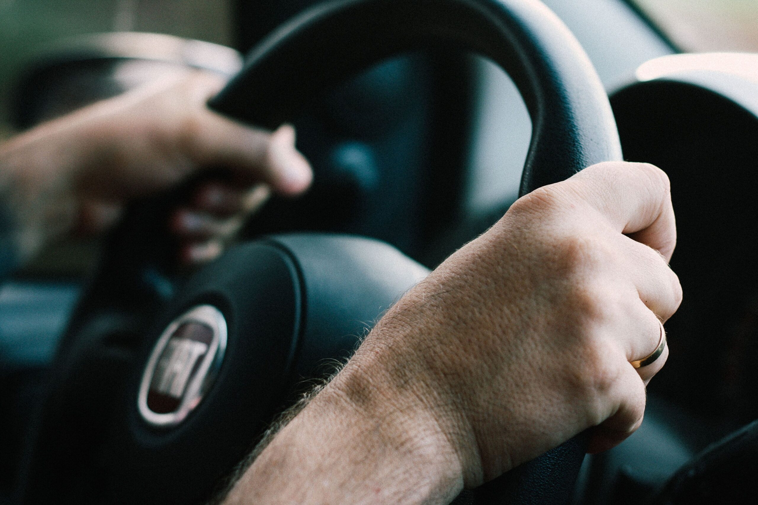 Mani di un conducente sul volante di un’automobile